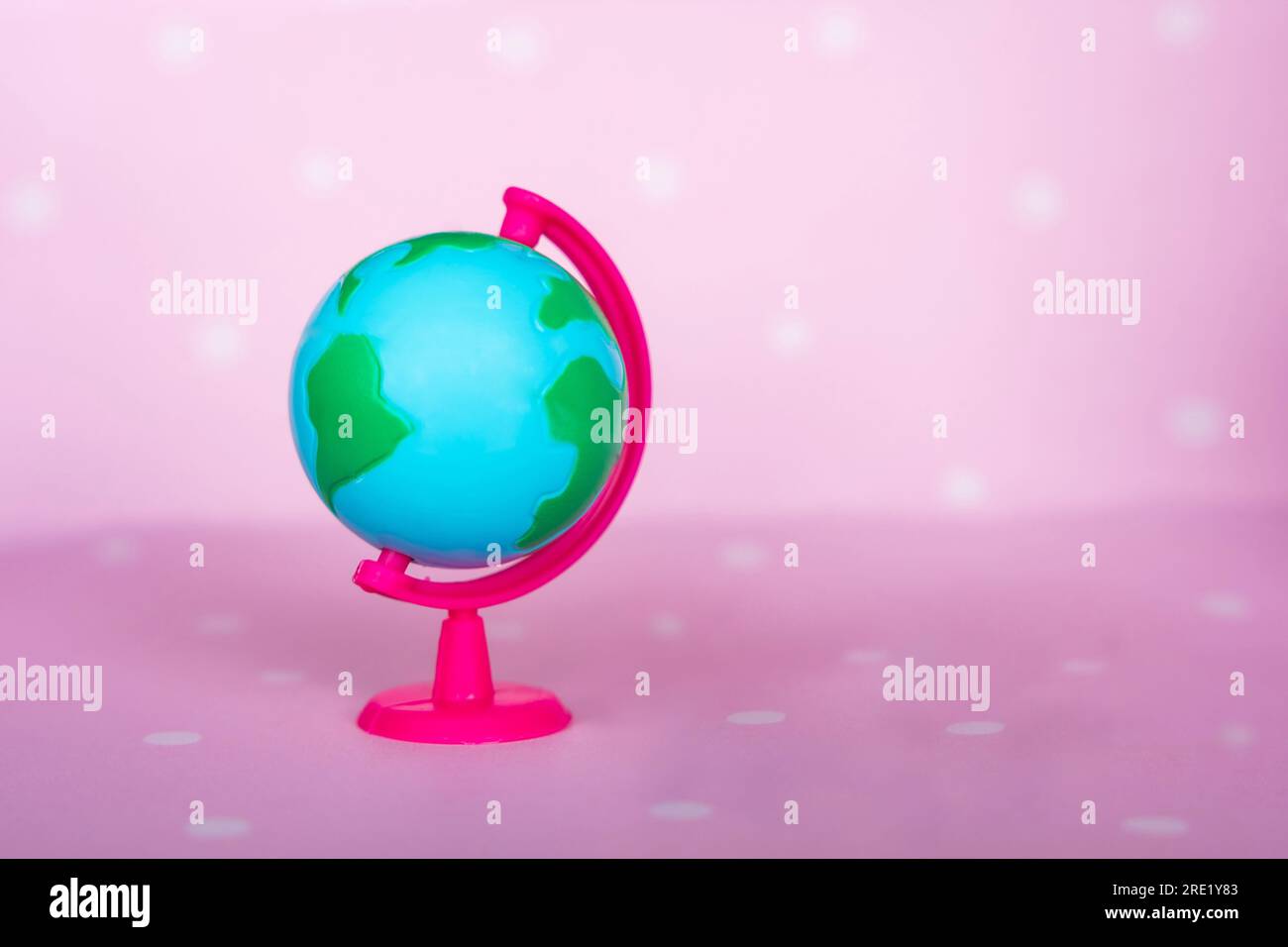 Kleine Spielzeugkugel auf pinkfarbenem Hintergrund Stockfoto