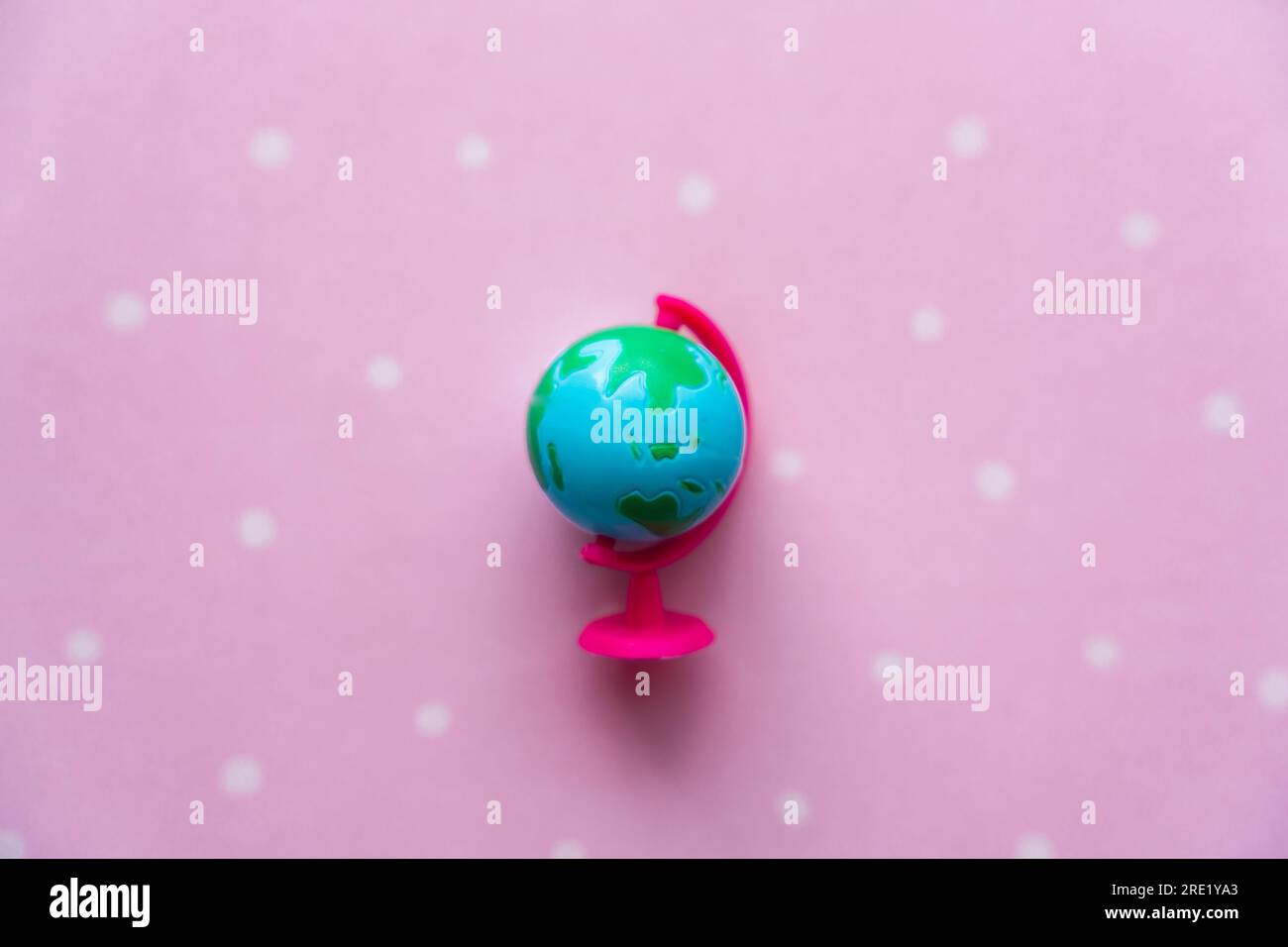 Kleine Spielzeugkugel auf pinkfarbenem Hintergrund Stockfoto