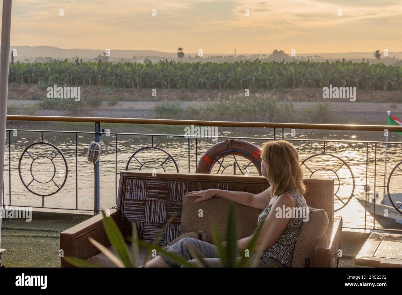 Frau, die die Aussicht von einem Nilboot aus betrachtet Stockfoto