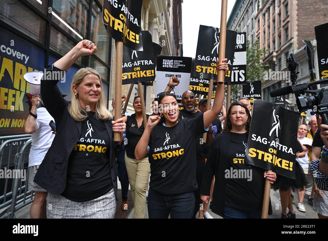 AFL-CIO-Präsidentin Liz Shuler und Alexandria Ocasio-Cortez schließen sich Mitgliedern der Screen Actors Guild an, während sie vor Warner Bros. Eine Streikpostenlinie überqueren Scheibe Stockfoto