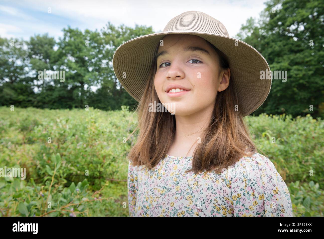 Ernte. Teenager mit breitem Hut auf dem Feld. Porträt bei der Arbeit Stockfoto