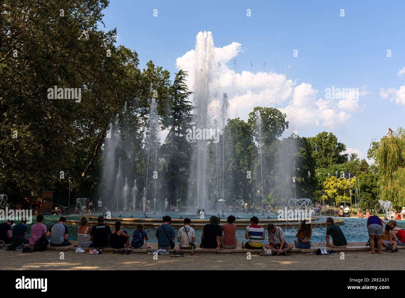 Menschen, die um den Brunnen am südlichen Ende der Margareteninsel in Budapest, Ungarn sitzen Stockfoto