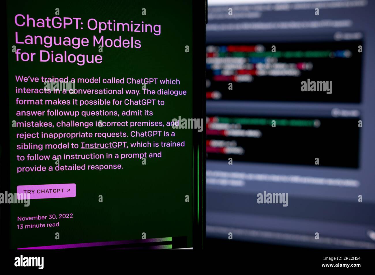 Azoren, Portugal - 16.01.2023: Smartphone-Bildschirm mit AI Chat GPT-Homepage. Entwickelt von OpenAI. Im Hintergrund ein Laptop-Bildschirm mit ChatGPT-Code Stockfoto