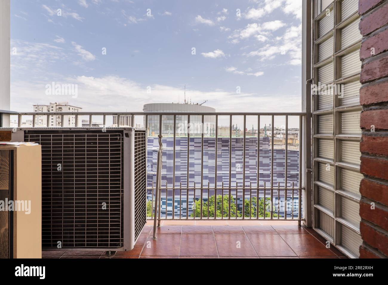 Kleine Terrasse eines Hauses mit Metallgeländer und Klimaanlage Stockfoto