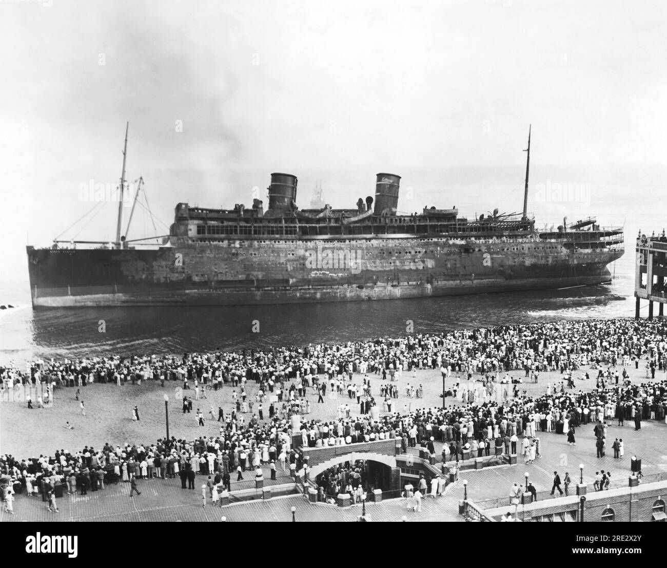Asbury Park, New Jersey: 9. September 1934 Zuschauer versammeln sich am Strand von Asbury Park, um das ausgebrannte Passagierschiff SS Morro Castle zu sehen. 137 Passagiere und Besatzungsmitglieder starben bei der Katastrophe. Stockfoto