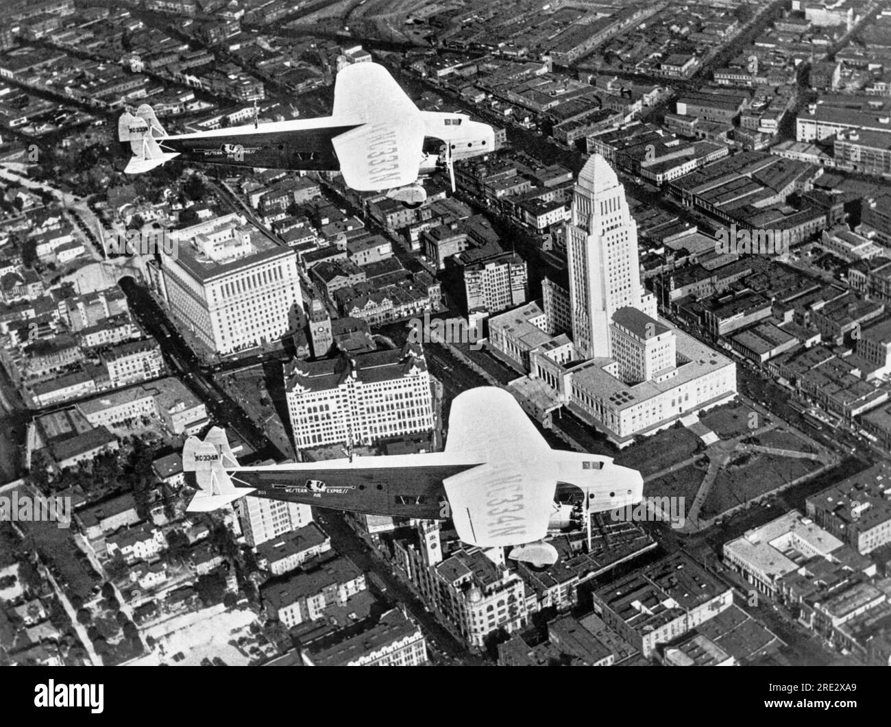 Los Angeles, Kalifornien: ca. 1929. Ein Luftblick auf Los Angeles mit zwei Fokker Monoplanen, die Western Air Express gehören und über das kürzlich fertiggestellte Rathaus fliegen. Stockfoto