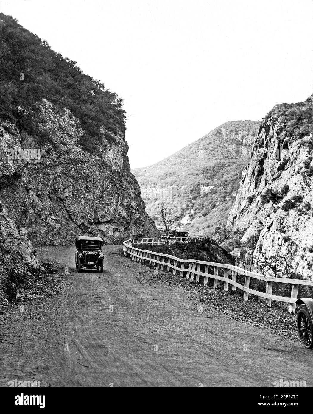 Topanga, Kalifornien: ca. 1922. Ein Auto mit einem Abzeichen kommt die Topanga Canyon Road in den Santa Monica Mountains hoch. Stockfoto