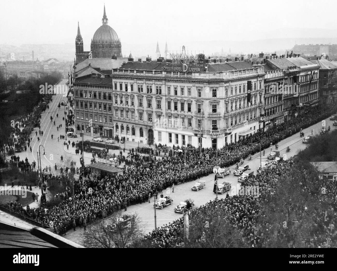 Wien, Österreich: 15. März 1938 Hitlers triumphaler Eintritt in Wien. Sein Auto steht ganz links hinter dem Baum, während ihm eine Parade anderer Fahrzeuge folgt. Stockfoto
