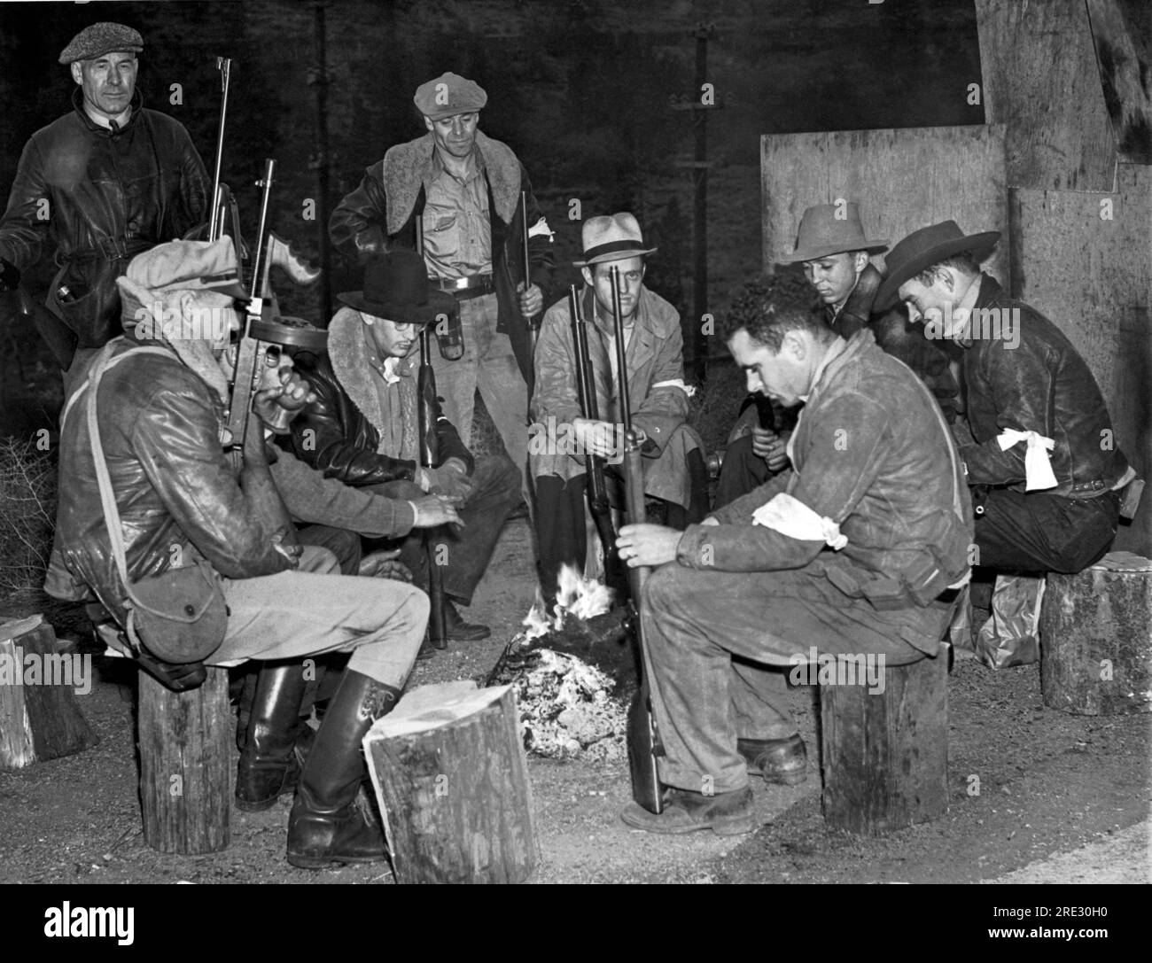 Verdi, Nevada: 10. Oktober 1938. Eine Gruppe von Truppen hält eine Lagerfeuerwache in Nevada in der Nähe der Staatsgrenze am Highway 50. Sie nahmen dort Posten auf, als eine Gruppe von CIO-Mitarbeitern aus Kalifornien mit der Invasion Nevadas drohte, um ein Hochstraßenprojekt zu bezwingen. Stockfoto