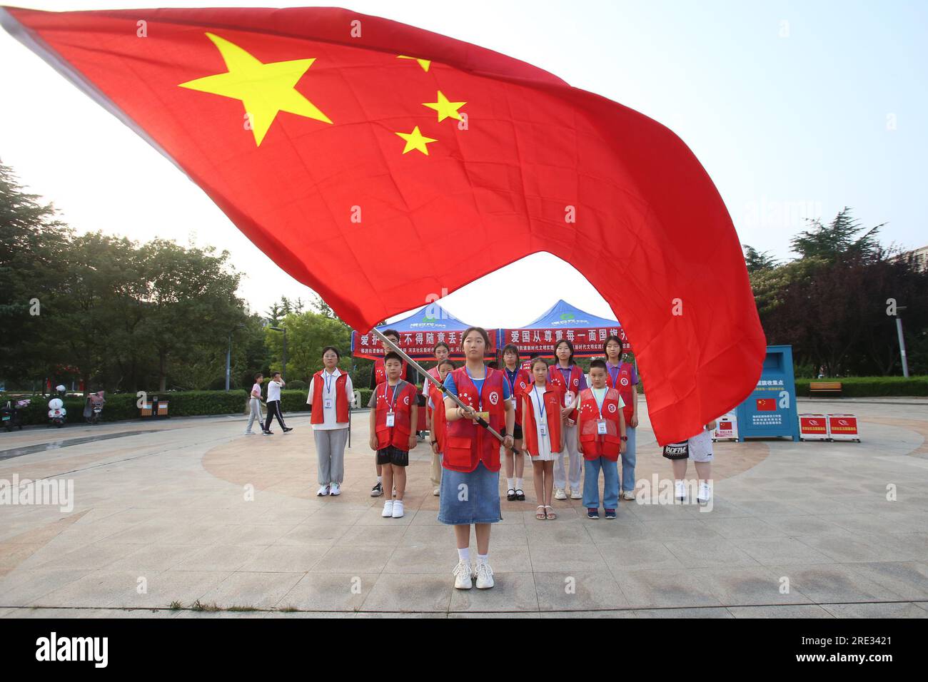 LIANYUNGANG, CHINA - 24. JULI 2023 - Freiwilliger Service-Team rekrutiert Flaggenträger vor Ort, 24. Juli 2023, Stadt Lianyungang, Provinz Jiangsu, China. Stockfoto