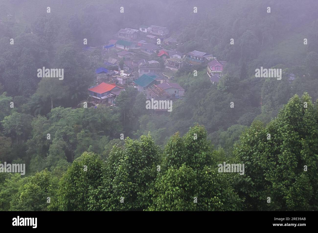Panoramablick auf das neblige und bewölkte Bergdorf, umgeben von grünem Wald in der Monsunzeit, in der Nähe der darjeeling Hill Station in westbengalen in indien Stockfoto