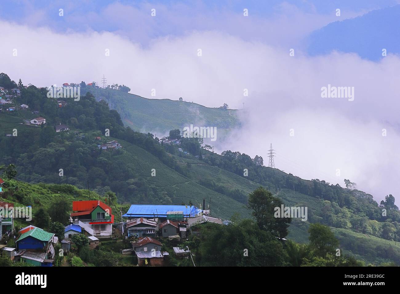 Panoramablick auf das neblige und bewölkte Bergdorf, umgeben von grünem Wald in der Monsunzeit, in der Nähe der darjeeling Hill Station in westbengalen in indien Stockfoto