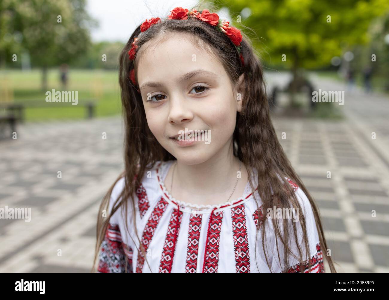 Ein süßes Mädchen, 6-7 Jahre alt, in einer ukrainischen Nationalbluse mit einem Ornament und einem Kranz im Haar. Stockfoto
