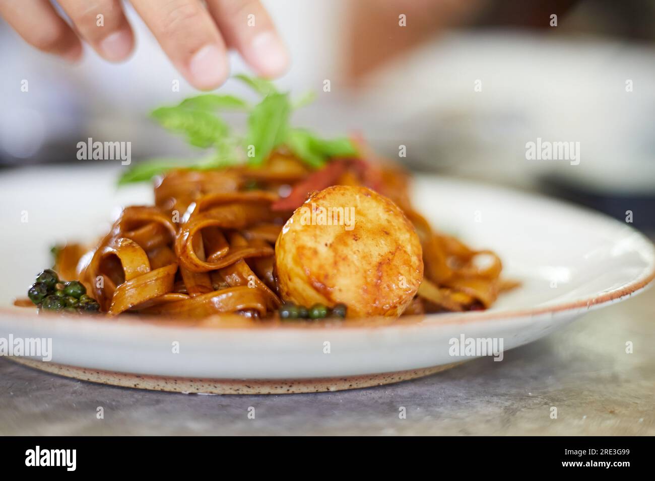Gebratene würzige Pasta mit Jakobsmuscheln umrühren, selektiver Fokus Stockfoto