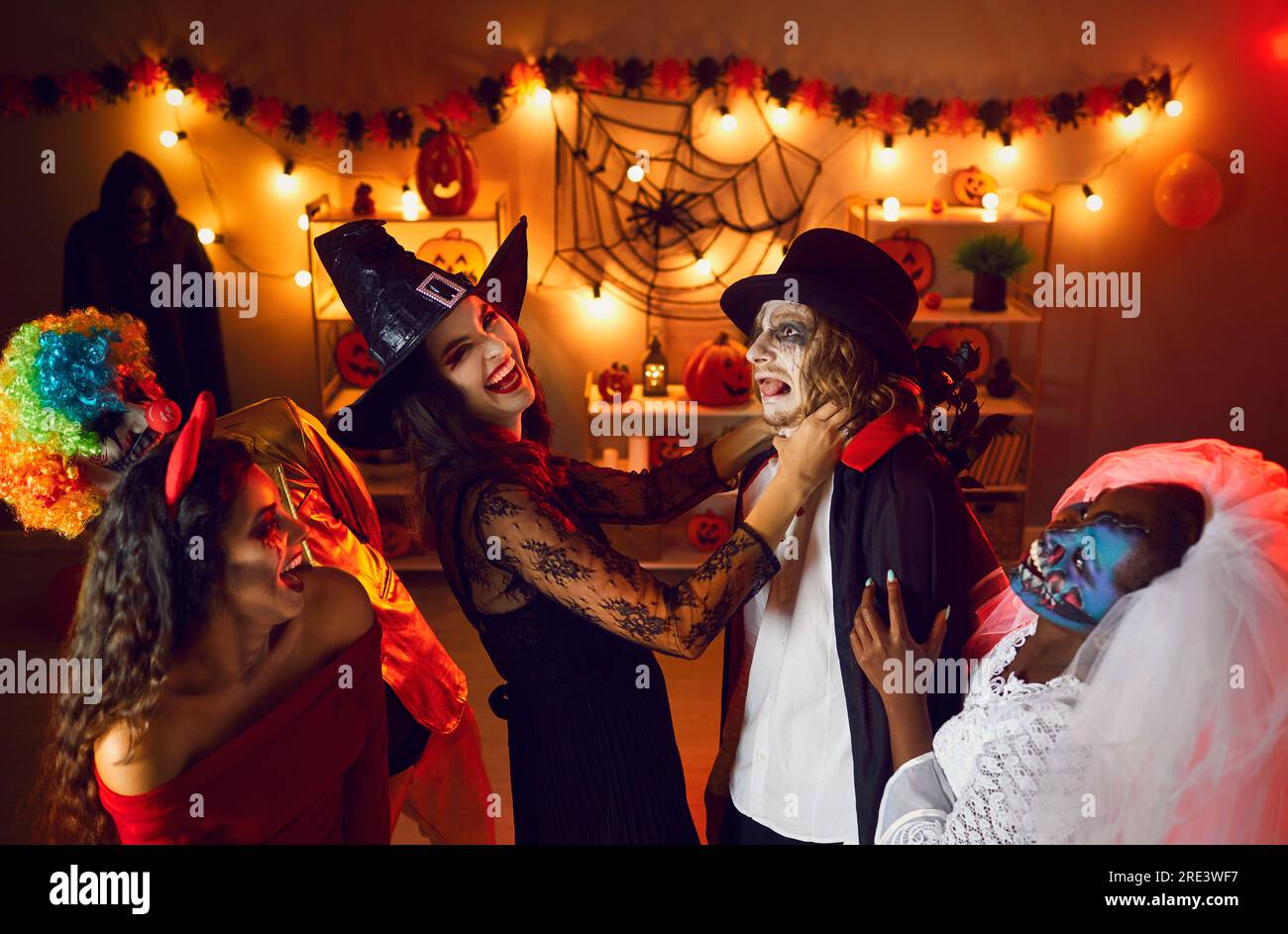 Eine Gruppe junger Männer und Frauen, die Spaß auf einer verrückten Halloween-Kostümparty zu Hause haben Stockfoto