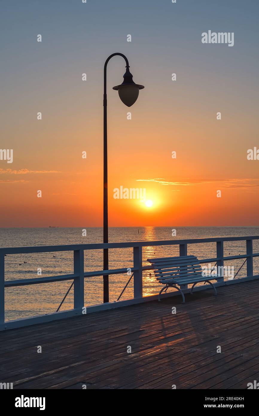 Farbenfrohe Morgenlandschaft am Meer. Holzpier am Meer bei Sonnenaufgang. Foto in Gdynia Orlowo an der Ostsee in Polen. Stockfoto