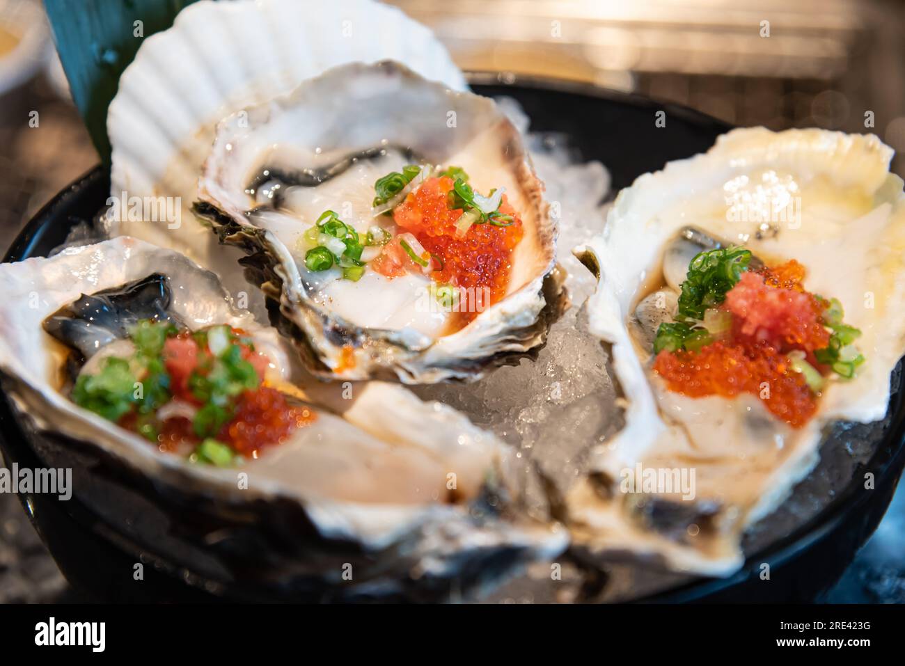 Japanisches Essen, rohe Auster mit Eiergarnelsoße auf Eis serviert Stockfoto