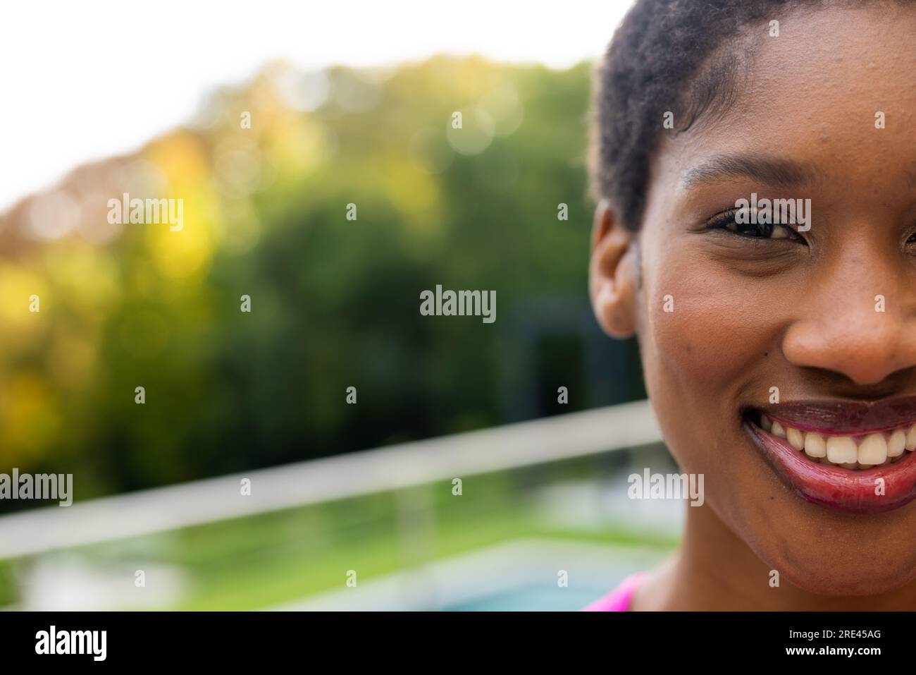 Ein halbes Porträt einer glücklichen afroamerikanischen Frau auf einer sonnigen Terrasse mit Kopierraum zu Hause Stockfoto