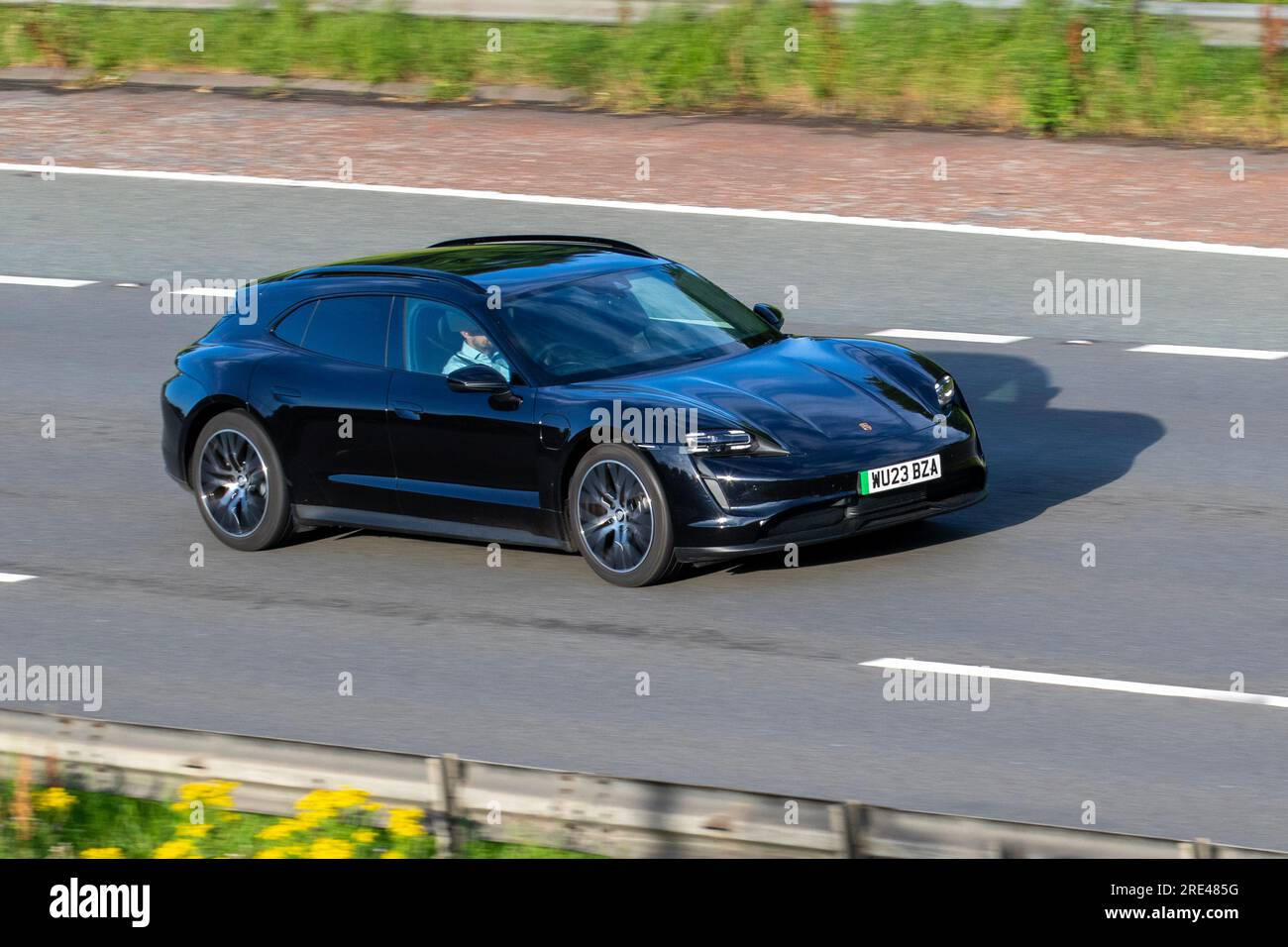 2023 Porsche Taycan Sport Turismo 4X2 476PS Performance Overboost 93,4Kwh Elektrischer Auto Black Car Estate Strom 280 kW Fahrt mit hoher Geschwindigkeit auf der Autobahn M6 im Großraum Manchester, Großbritannien Stockfoto