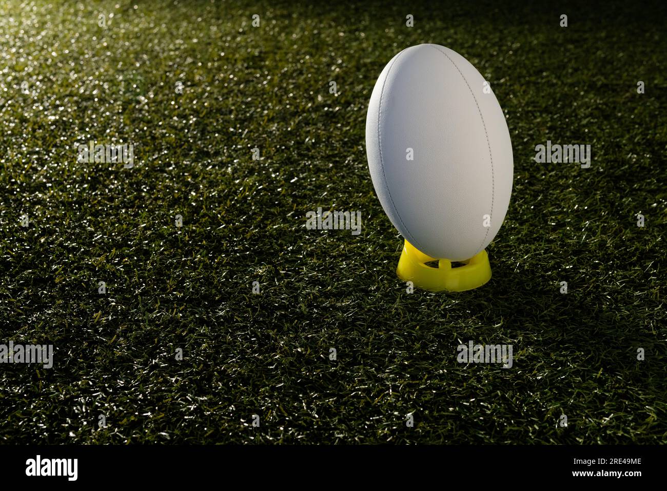 Weißer Rugby-Ball über Gras mit Kopierraum in Zeitlupe Stockfoto