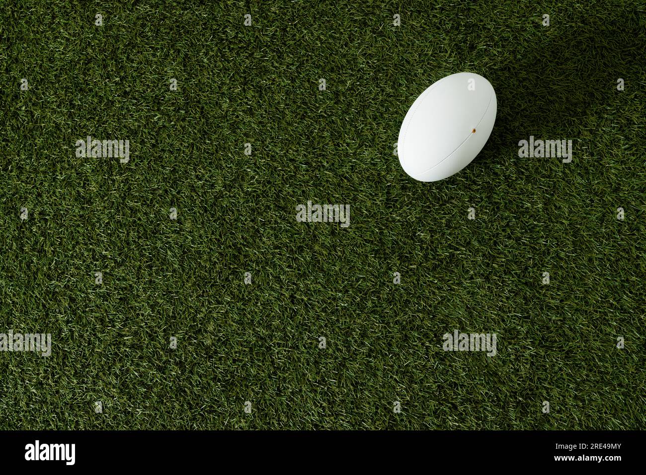Weißer Rugby-Ball über Gras mit Kopierraum in Zeitlupe Stockfoto