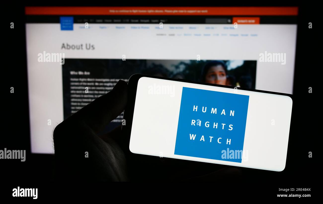 Person, die ein Smartphone mit dem Logo der Organisation Human Rights Watch (HRW) auf dem Bildschirm vor der Website hält. Konzentrieren Sie sich auf das Display des Telefons. Stockfoto