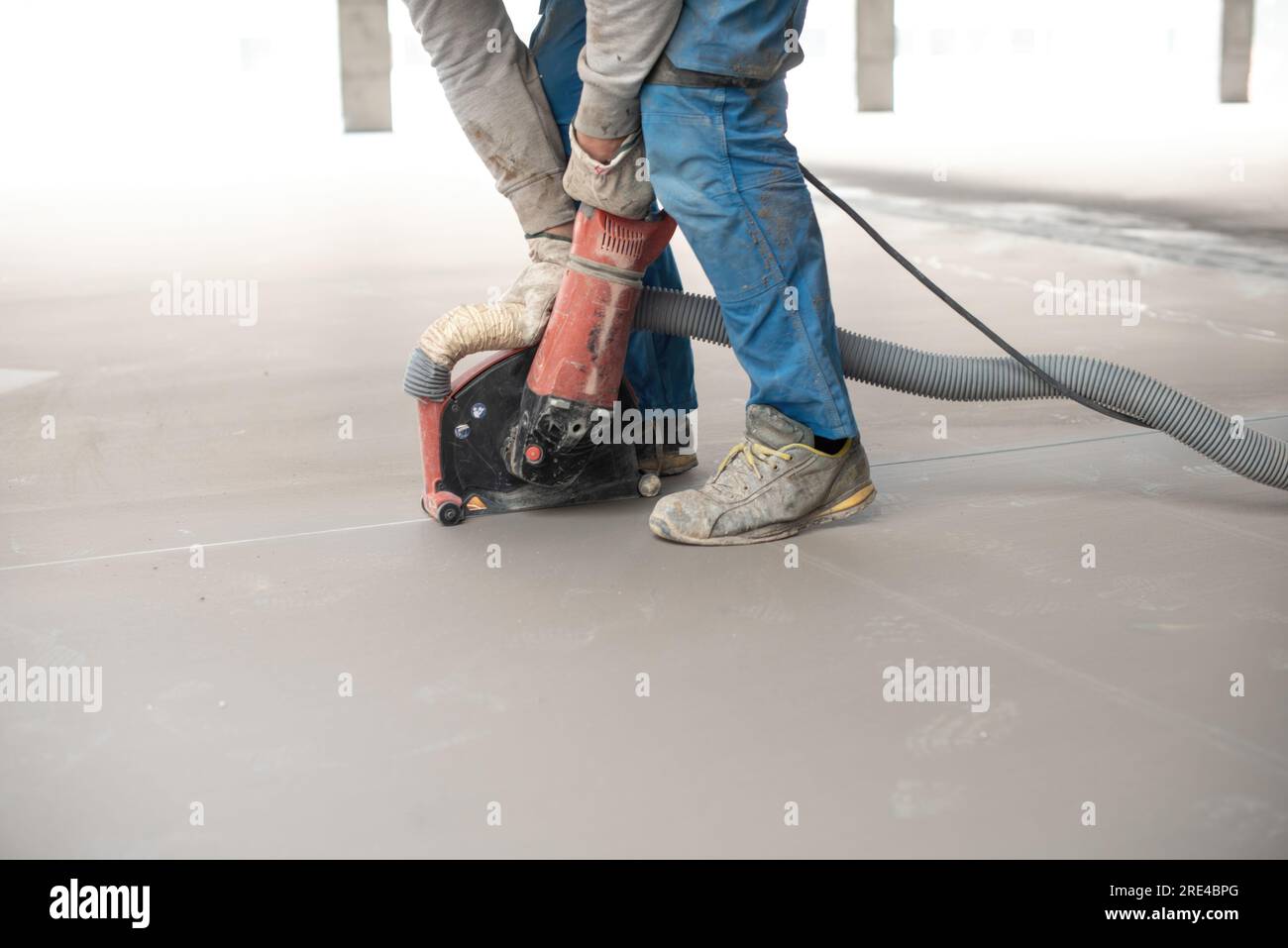 Beim Planieren des Bodens mit der Maschine während der Bauarbeiten anonyme Personen ernten Stockfoto