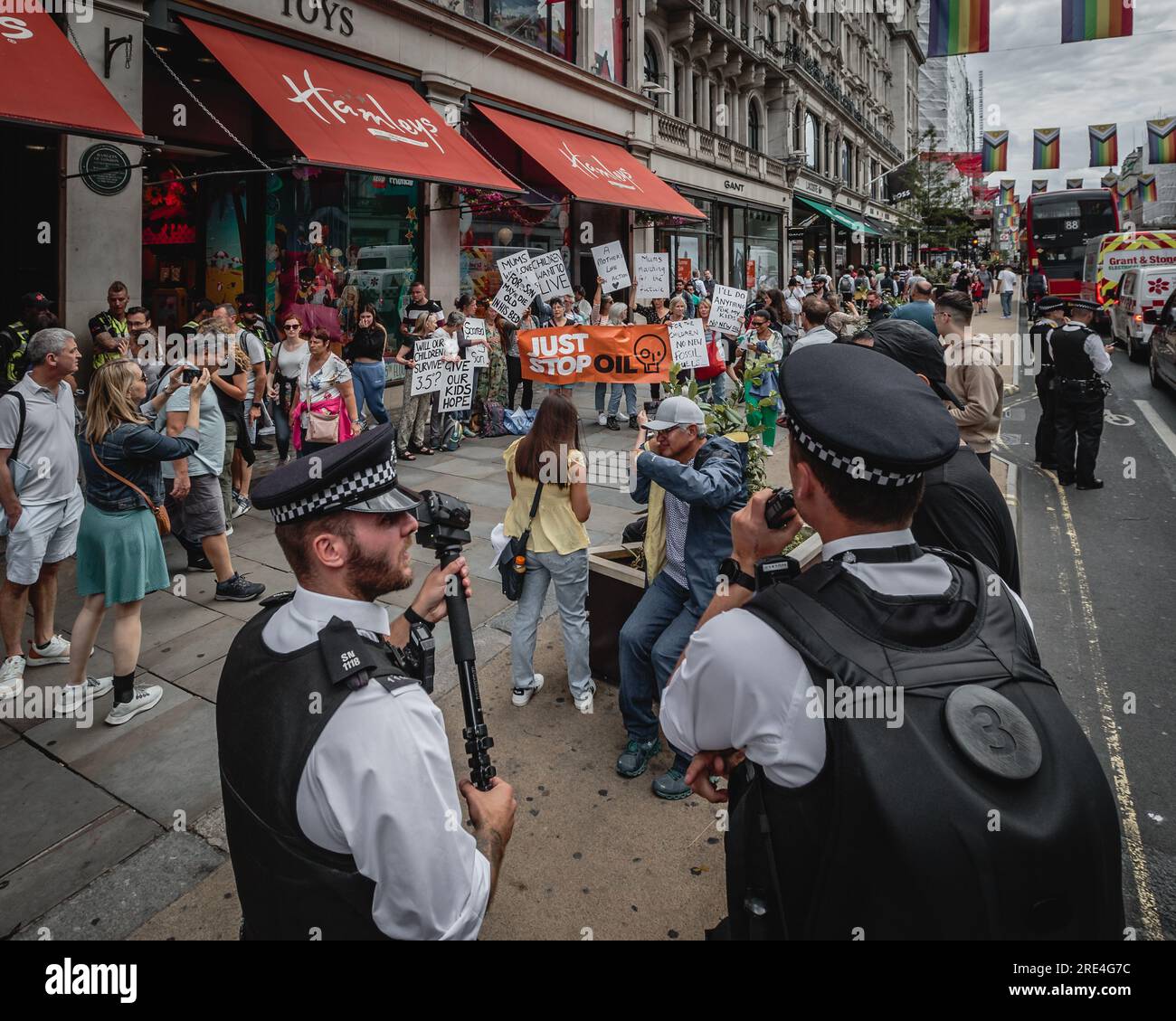Polizei und Touristen mischen sich mit Just Stop Oil Demonstranten vor dem Hamleys Spielzeugladen in London. Stockfoto