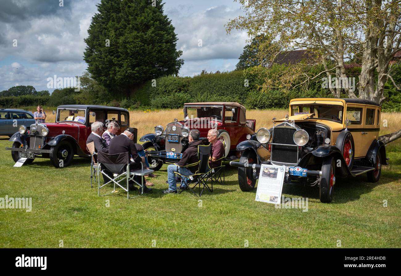 Eine Gruppe männlicher Enthusiasten sitzt auf Picknickstühlen vor ihren makellosen alten 1930er-Autos, die auf einer Oldtimer-Ausstellung in Storrington, West, ausgestellt werden Stockfoto