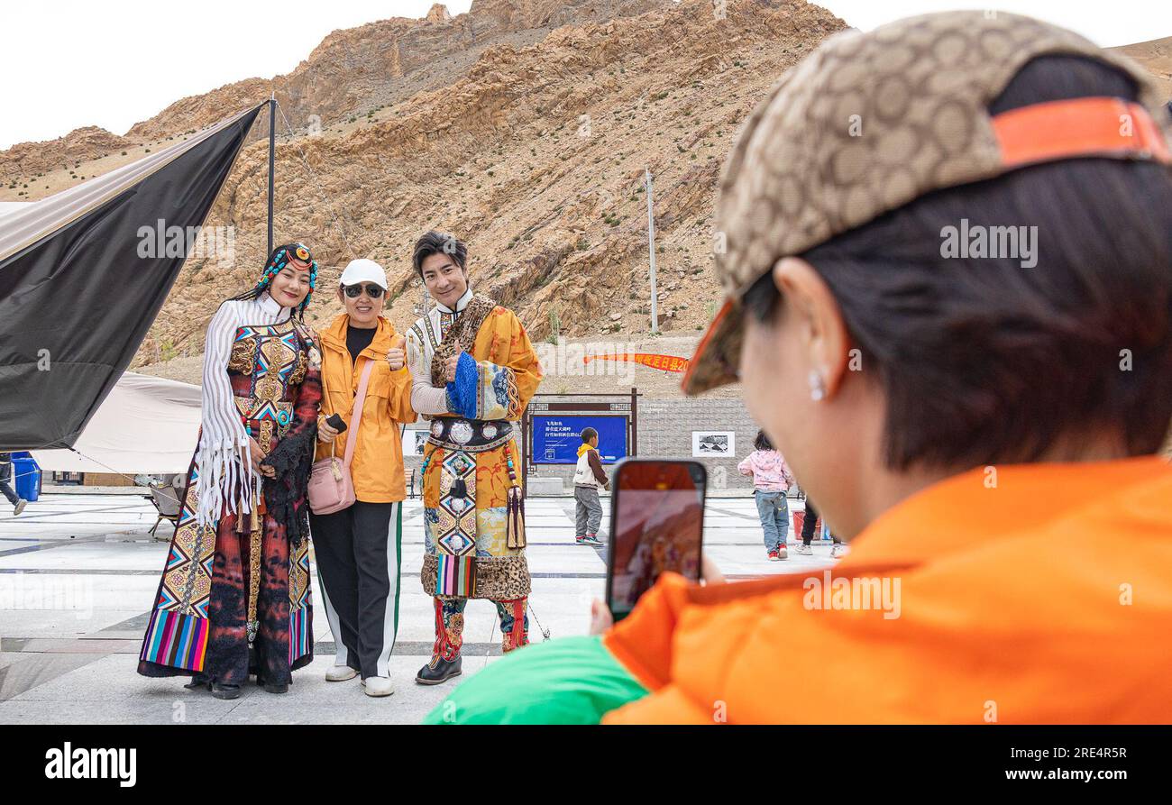 (230725) -- LHASA, 25. Juli 2023 (Xinhua) -- Ein Tourist posiert für Fotos mit Künstlern bei einem Musik- und Food Festival in Zhaxizom Township, Tingri County, Südwestchina Autonome Region Tibet, 23. Juli 2023. FÜR „Across China: Music Festival energiespendend für eine kleine Stadt am Fuß des Mount Qomolangma“ (Foto von Tenzin Nyida/Xinhua) Stockfoto