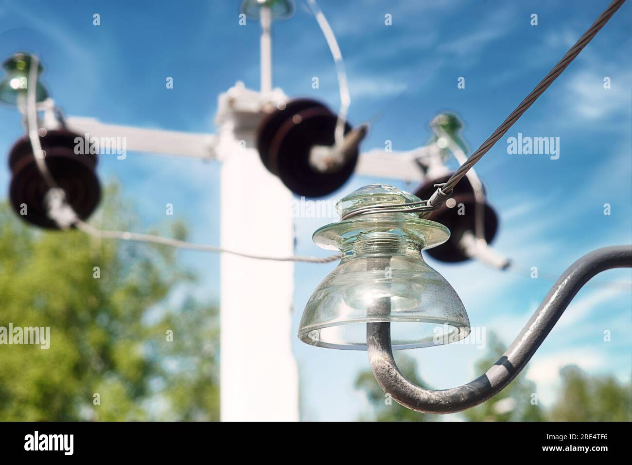 Glasisolator am Hochspannungspolpol. Nahaufnahme zum Himmel. Hochspannungsleitungen. Hintergrund. Stockfoto