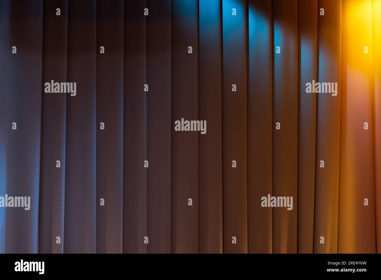 Geschlossener weißer wellenförmiger Vorhang mit Bühnenbeleuchtung aus bunten Spots und Fotostruktur im Hintergrund Stockfoto