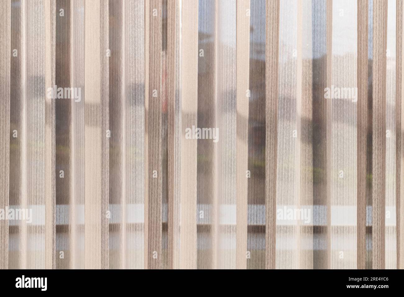 Welliges Tüll vor einem Fenster an einem Tag. Fotostruktur des Hintergrunds Stockfoto