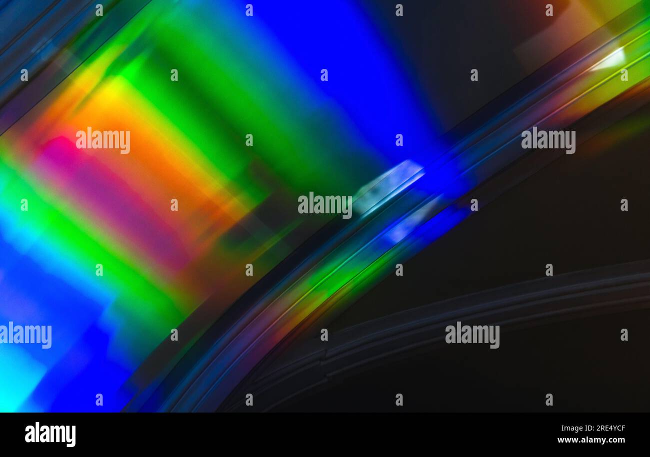 Farbenfrohes Lichtmuster in Regenbogenfarben über dunkler Wand, abstraktes Hintergrundfoto Stockfoto