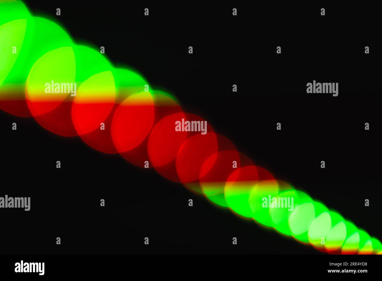 Abstrakter, verschwommener Fotohintergrund mit natürlichem Bokeh-Effekt von roten grünen LED-Streifen, Makrofoto mit selektivem Weichzeichner Stockfoto