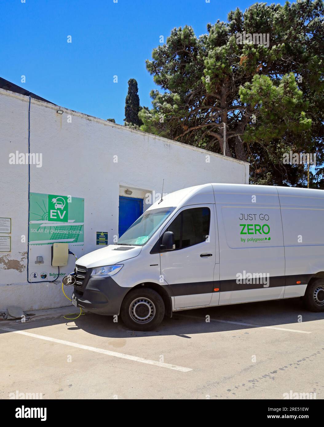 Polygreen „Just Go Zero“-Van an der Ladestation für Elektrofahrzeuge, Insel Tilos, in der Nähe von Rhodos, Dodekanesisch, Griechenland Stockfoto