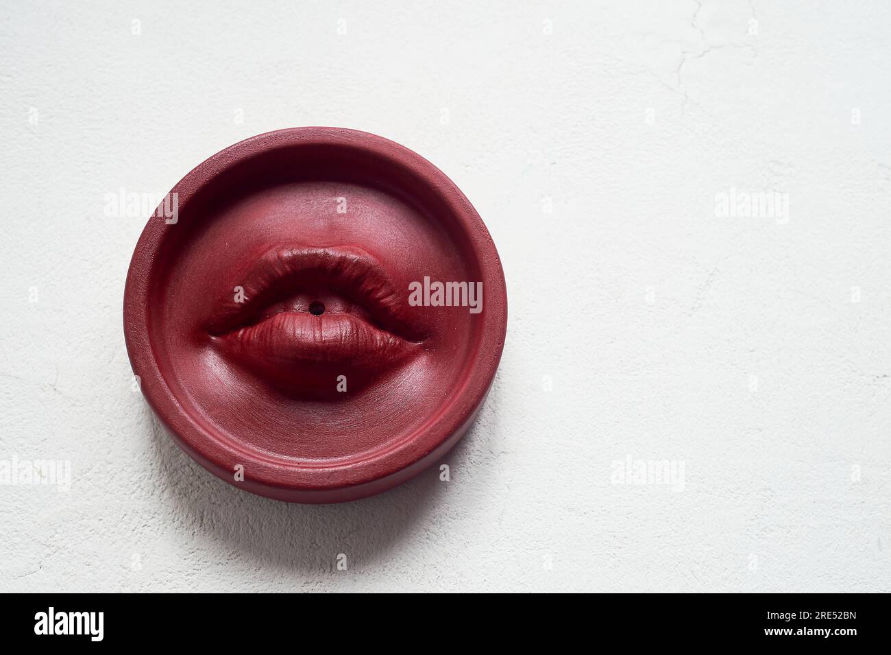 Räucherstäbchen, rote Lippen. Runde Form auf weißem Hintergrund. Esoterismus, Meditation. Stockfoto