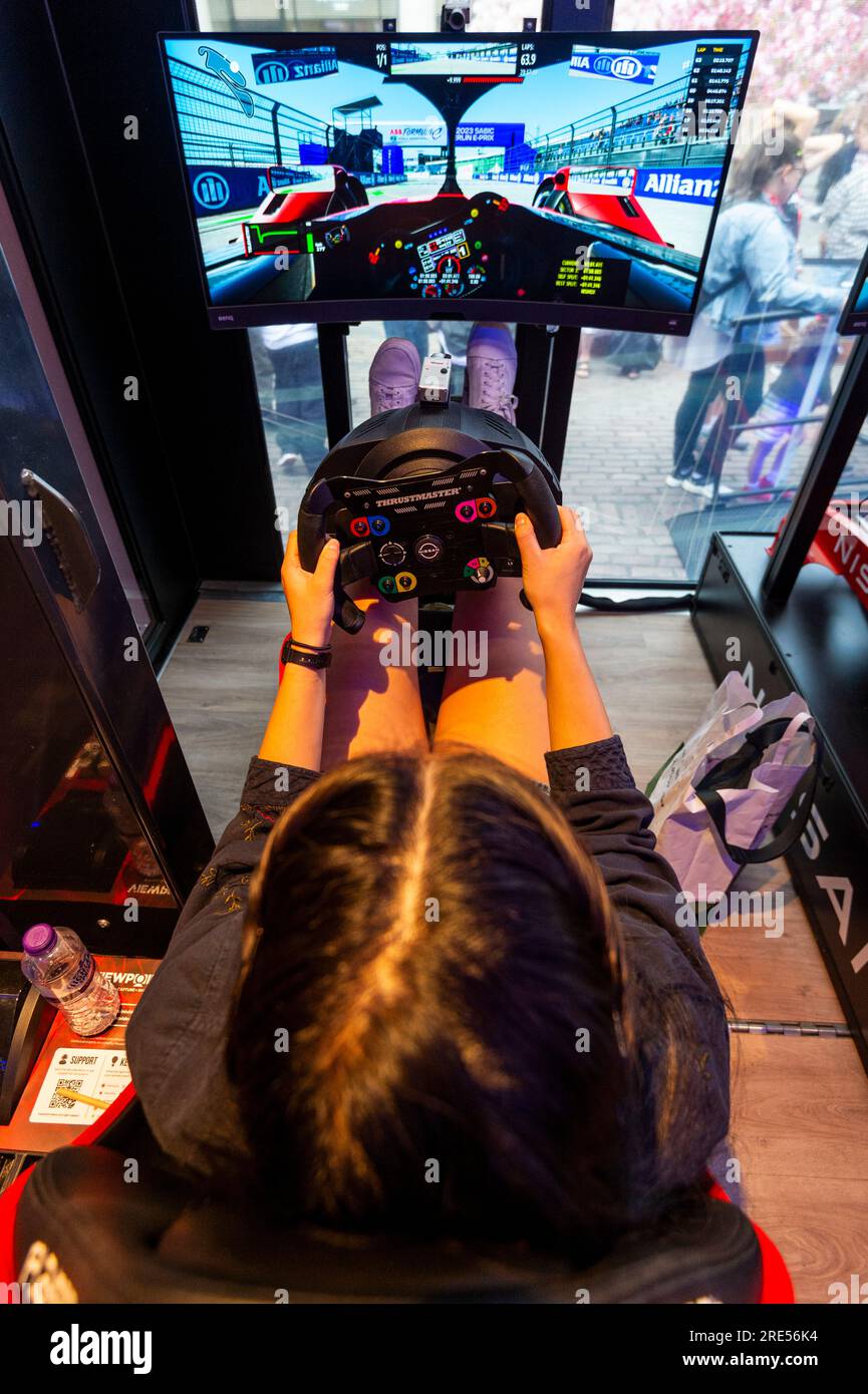 London, Großbritannien. 25. Juli 2023 Besucher erleben einen Rennsimulator beim Feel Electric Festival in Covent Garden Piazza, das vom Nissan Formula E-Team ausgerichtet wird und bis zum 30. Juli stattfindet, dem Tag, an dem das Finale der Hankook London E-Prix-Saison 2023 um das Excel Centre in den Royal Victoria Docks stattfindet. Im Covent Garden können Besucher einen Cherry Blossom Garden sowie das Nissan Formula E Lab besuchen, um die Rennsimulatoren auszuprobieren. Credit: Stephen Chung / Alamy Live News Stockfoto