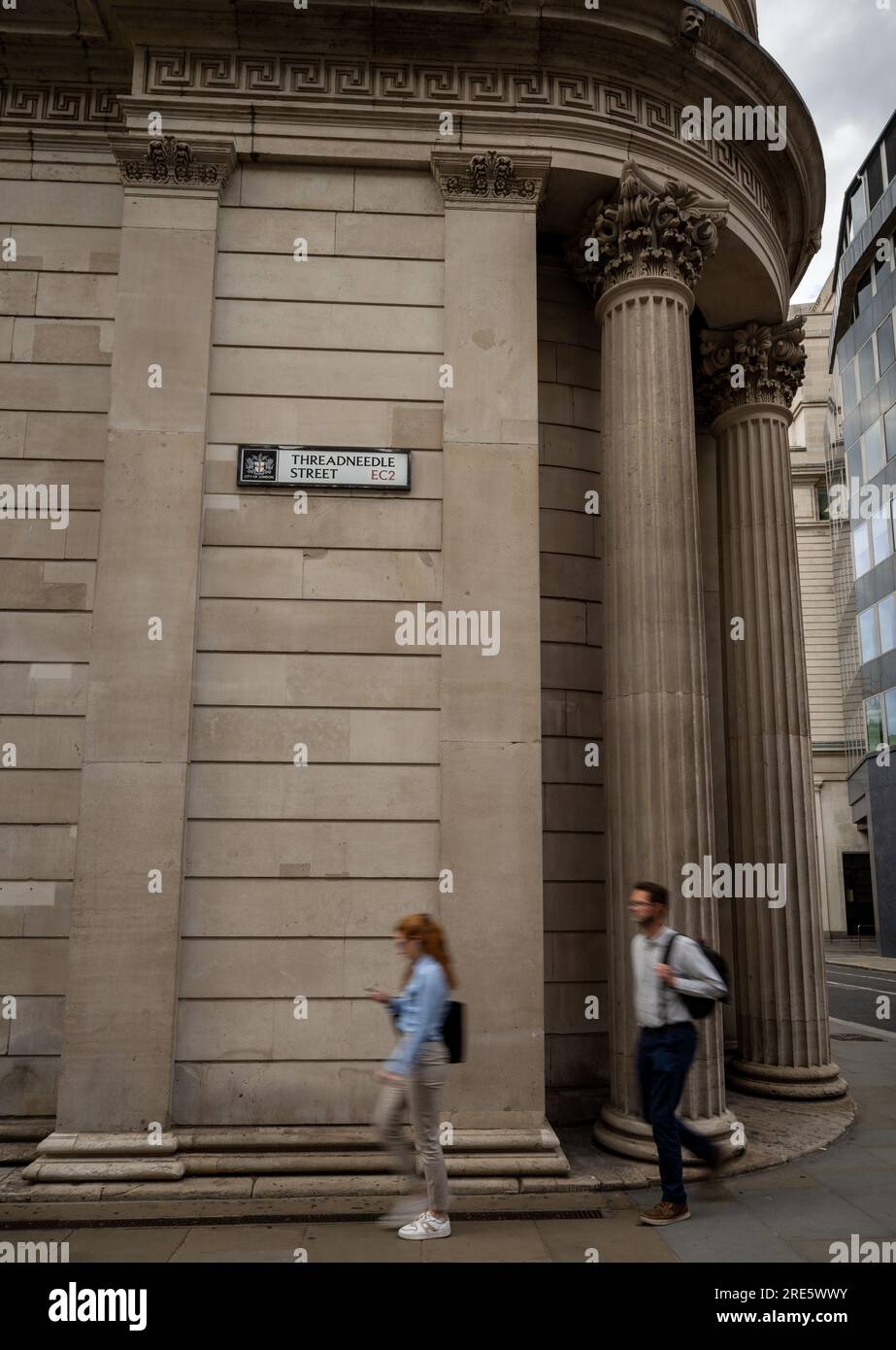 London, Vereinigtes Königreich: Menschen, die an der Bank of England auf der Threadneedle Street in der City of London vorbeigehen. Das Straßenschild ist an der Wand. Stockfoto