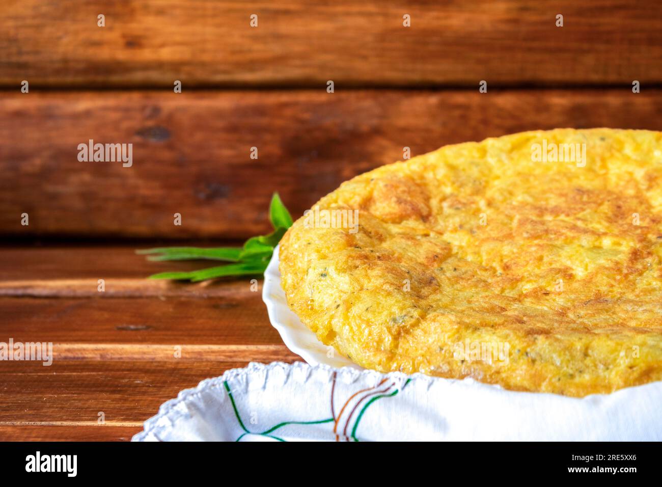 spanisches Kartoffelomelett mit Knoblauch und Petersilie. Nahaufnahme von Kartoffelomelette auf braunem Holzhintergrund Stockfoto