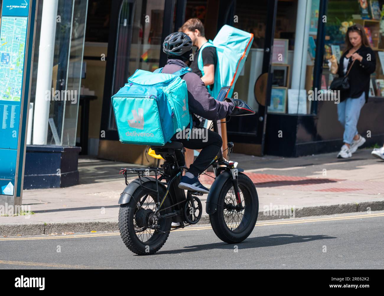 Radfahrer auf einer Fahrradauslieferung für Deliveroo in Brighton & Hove, East Sussex, England, Großbritannien. Stockfoto