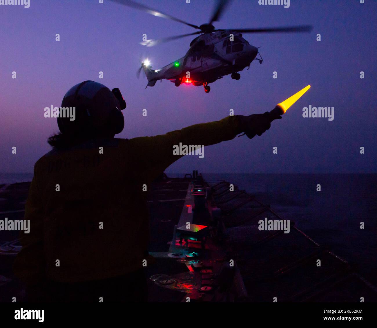 Golf von Oman, Oman. 22. Juli 2023. U.S. Navy Sailor CT1 Lynea Arriaga signalisiert einem H225 Super Puma Helikopter, der auf dem Flugdeck der Arleigh-burke-Klasse-Guided-Raketenzerstörer USS Paul Hamilton landet, während er internationale Schifffahrtsrouten patrouilliert, 22. Juli 2023 im Golf von Oman. Die USA Die Navy verstärkte Patrouillen, nachdem der Iran die zivile Schifffahrt in der Region schikaniert hatte. Kredit: MC2 Elliot Schaudt/Planetpix/Alamy Live News Stockfoto