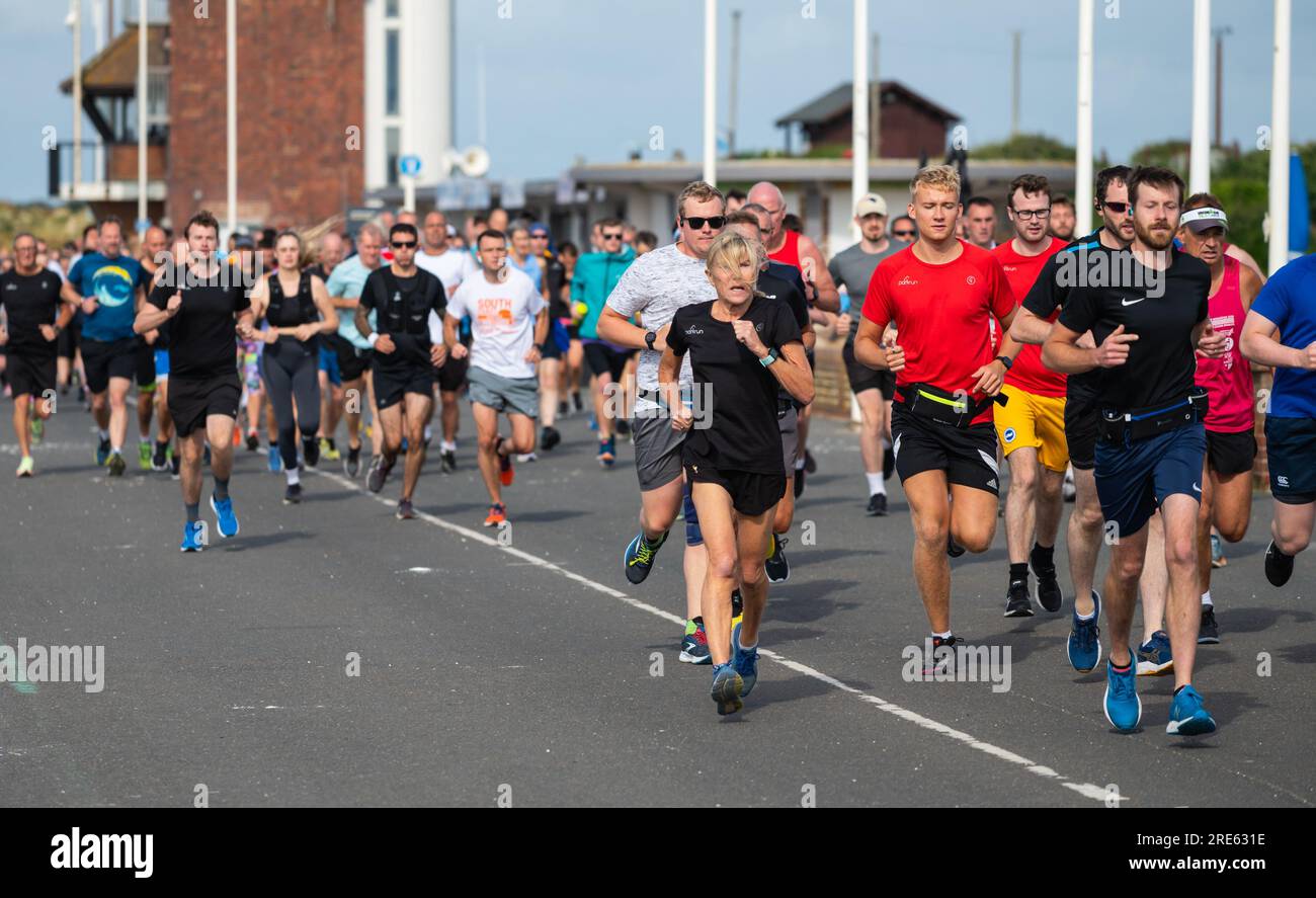 Läufer beim wöchentlichen Parkrun (Park Run), einem Community Event, das an der Uferpromenade in Littlehampton, West Sussex, England, Großbritannien, verläuft. Stockfoto
