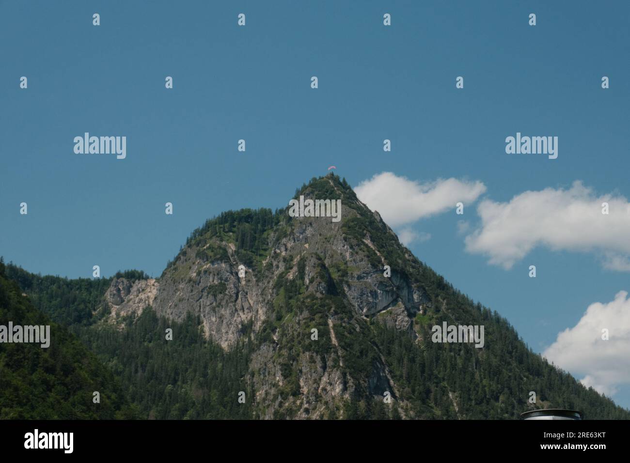 Ein fesselnder Blick auf einen üppigen, grünen Hügel am Königssee, Bayern, der die unberührte Natur der Region und atemberaubende Landschaften widerspiegelt. Stockfoto