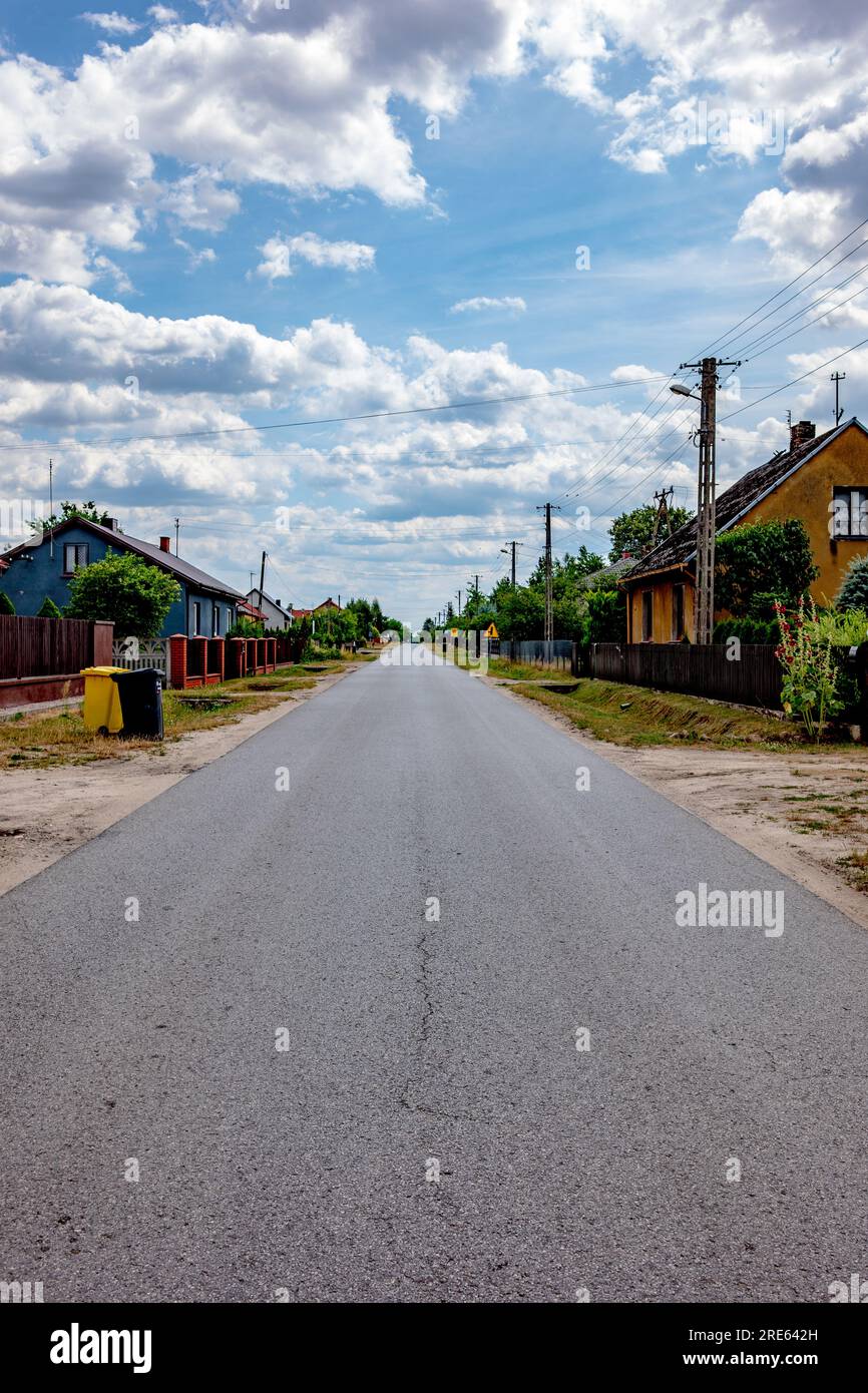 Eine einzige leere polnische Dorfstraße, keine Autos, ländliche Gemeinde, polnische Landschaft, Dorfleben Stockfoto