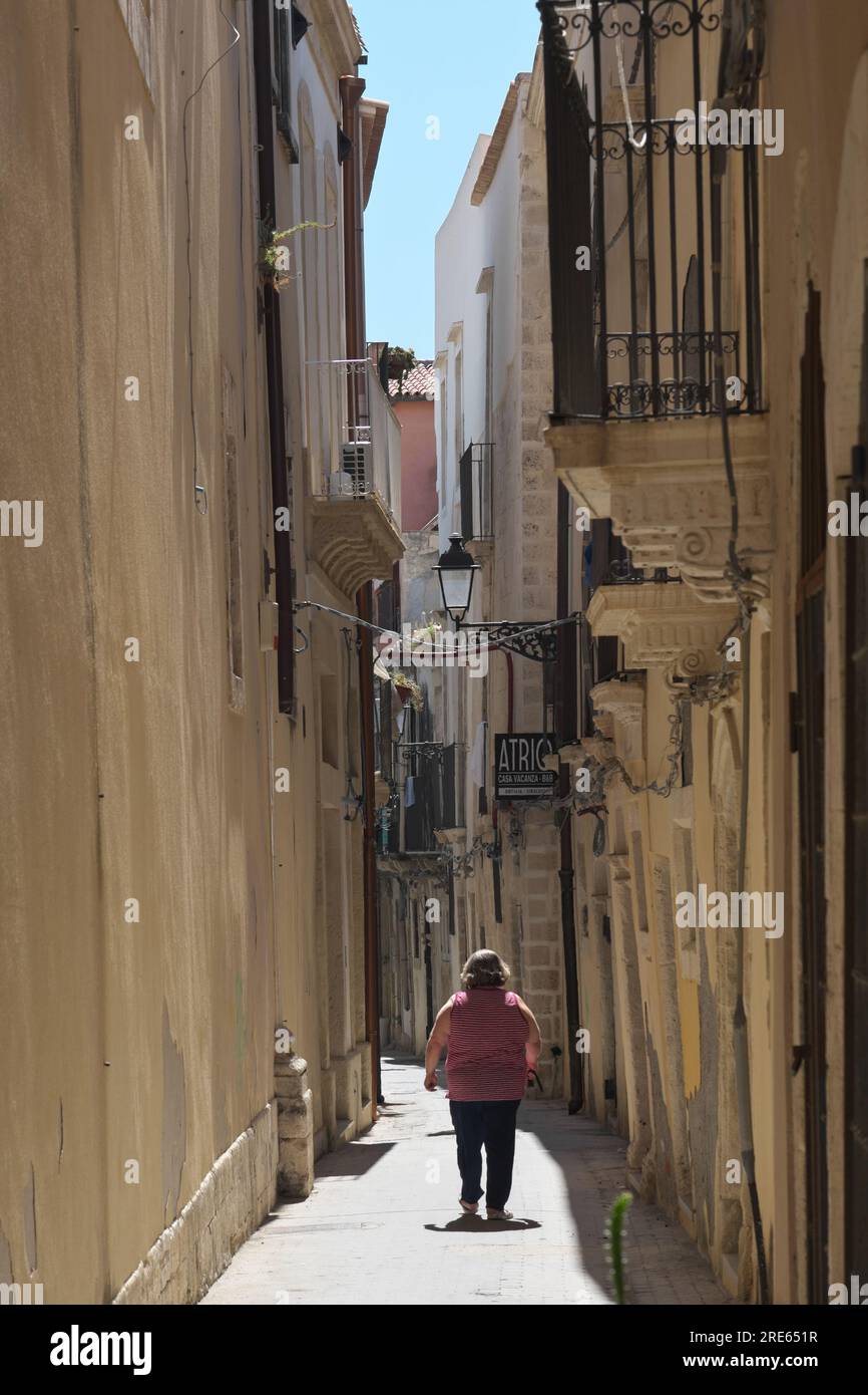 Fette Frau in einer engen Gasse in Ortigia, Siracusa, Sizilien, Italien Stockfoto