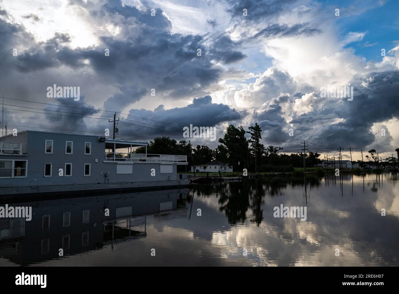 Ein weiterer Winkel von Bayou Lafourche und dem Hausboot über den Bayou. Reflektierter Himmel und Hausboot im relativ ruhigen Bayou. Stockfoto