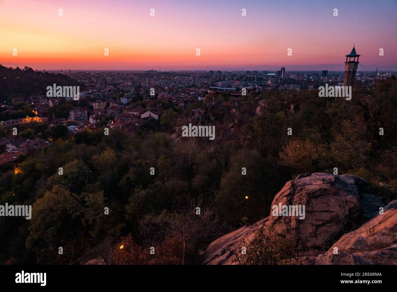 Sonnenuntergang vom Danov-Hügel in der Stadt Plowdiw, Bulgarien. Auf der rechten Seite ist ein historischer Uhrenturm aus dem Jahr 1812 zu sehen Stockfoto