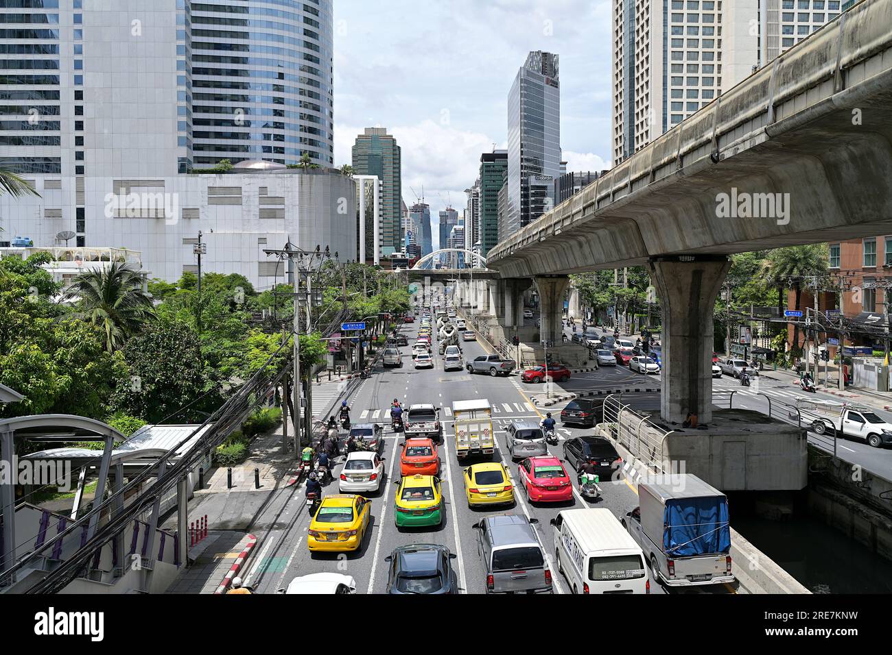 Geschäftiger Verkehr an Wochentagen entlang der North Sathon Road, Bangkok, mit dem Chong Nongsi Skywalk im Hintergrund und Silom BTS Skytrain Line auf der rechten Seite Stockfoto