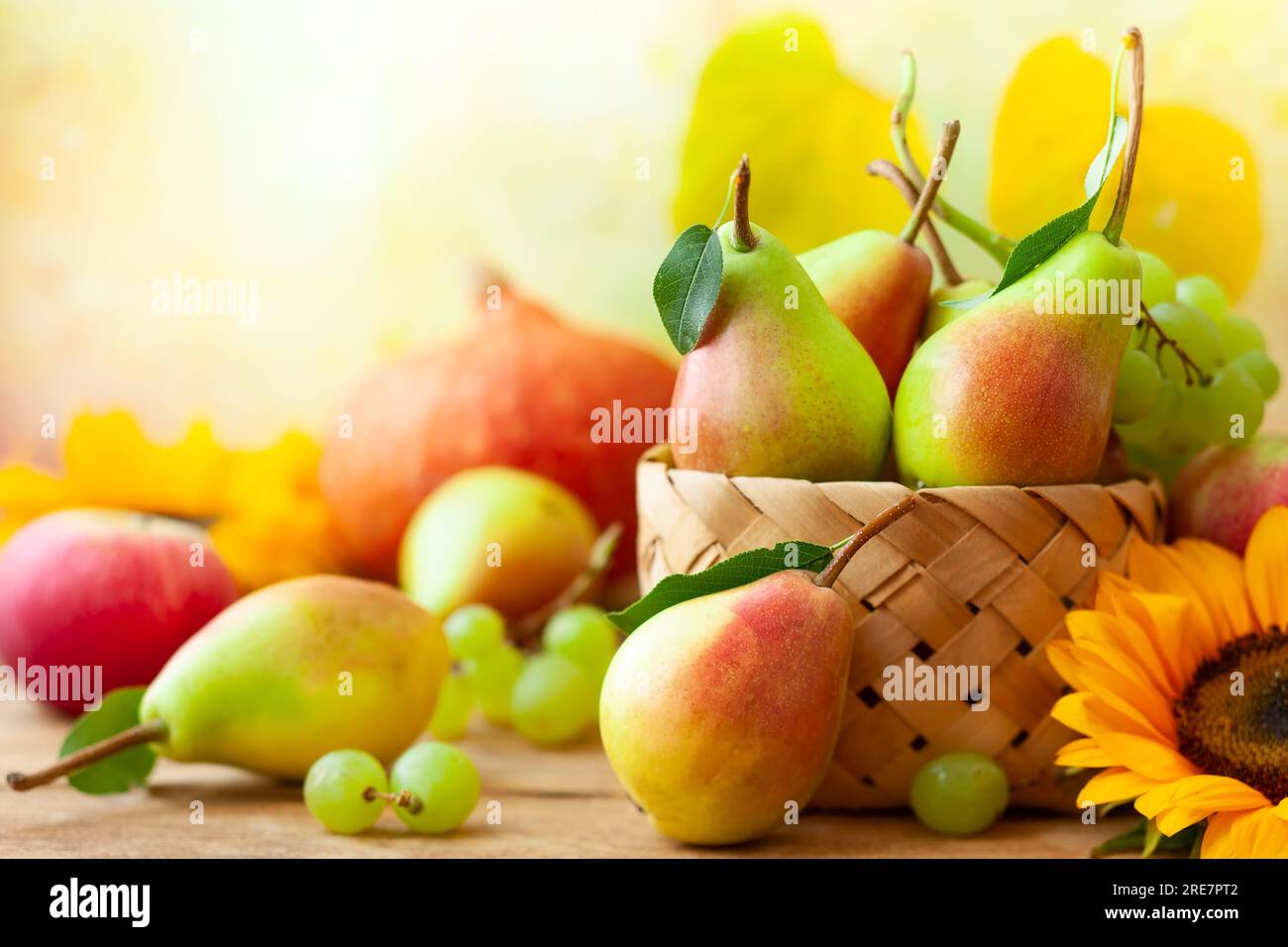 Herbstleben mit Obst, Blumen und Gemüse der Saison auf Holzhintergrund. Stockfoto